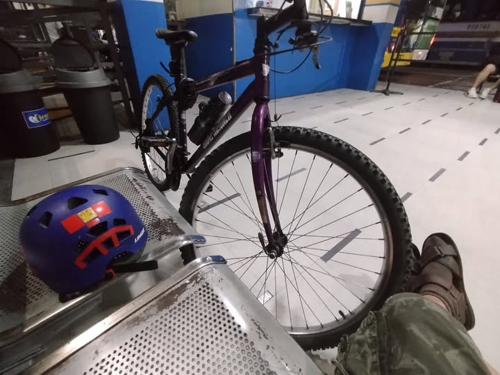 Me on my bike, buying a bus ticket for my endless, pathless travels